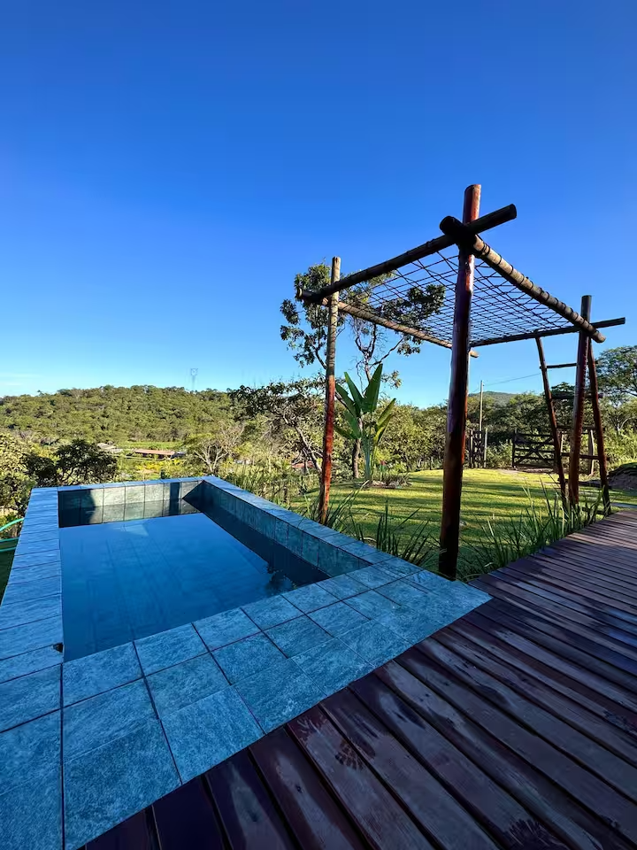 Deck e piscina privativa do Chalé Fazenda dos Milagres com vista para as montanhas